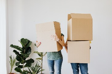 Two people holding boxes
